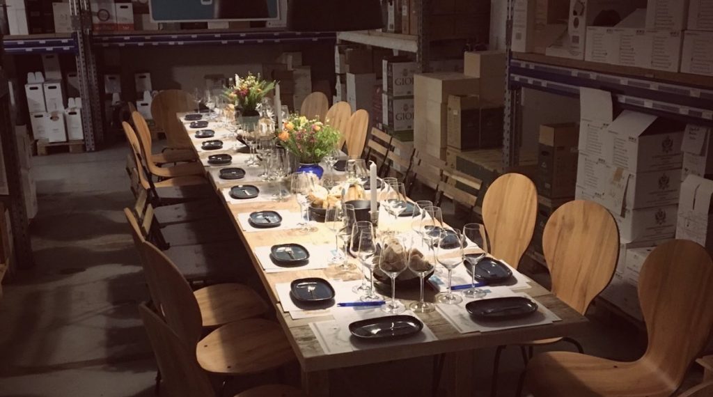 Das athmosphärische Bild zeigt eine gedeckt Tafel mit dezenter Beleuchtung - alles ist bereit für eine Weinverkostung